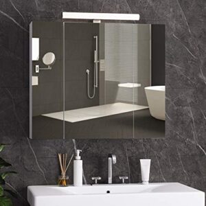 Spiegelschrank mit LED-Beleuchtung, Steckdose und lichtschalter im Badezimmer. Drei Türen, Spiegel, Hängeschrank und Badspiegel in Weiß.