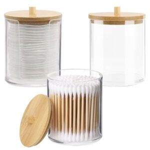 Drei transparente Acryl-Wattepads-Aufbewahrungskästchen mit Bambusdeckel und Holzdeckeln für die Aufbewahrung von Wattestäbchen, Wattpads und Zahnseidepicks.